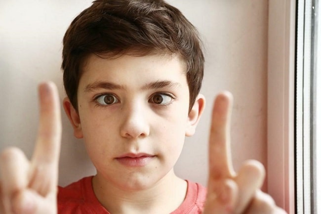 A young boy looking at his two fingers