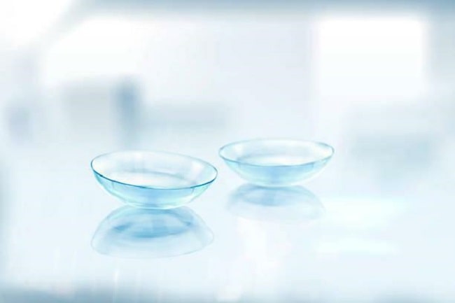 A pair of transparent lenses placed side by side on a flat surface.