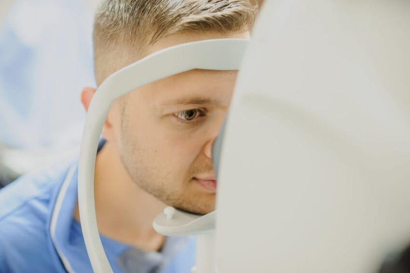 A man in a blue shirt looking in a machine