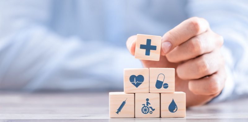 A person holding wooden blocks with medical symbols.